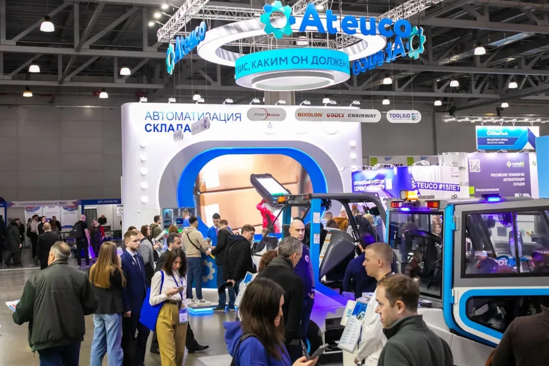 Visitors explore warehouse automation technologies at TRST Expo. A modern exhibition hall showcasing logistics vehicles, automation systems, and innovative warehouse solutions. Industrial design and business networking atmosphere.